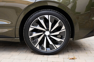 Modern electric car wheel. Close up tires on a road. Detail of car tires on the road. New electric vehicle rear wheel © uflypro