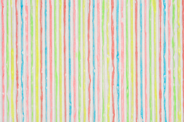 A vibrant, vertical abstract background of a white, corrugated surface painted with irregular,...