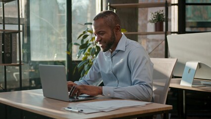 Obraz premium African American 40s business man typing laptop web service cyberspace adult businessman working online at office smiling mature male executive worker manager developer with computer data programming