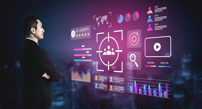 A business professional standing thoughtfully next to a digital display of data visuals featuring graphs, metrics, and target icons in an urban night setting. Gantry - Powered by Adobe