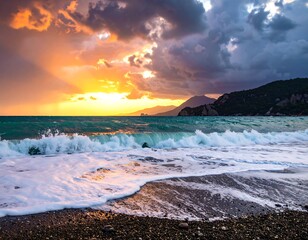 Dramatic coastal scene sunset illuminates foamy waves crashing on a pebble beach against mountains under a stormy sky