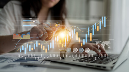 A business professional engages with digital financial data on a laptop, depicting a modern approach to market analysis with interactive graphs and charts. Gantry