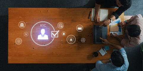 Professionals collaborate in a modern workspace, emphasizing the importance of KYC processes with digital icons that symbolize security and verification. Trope