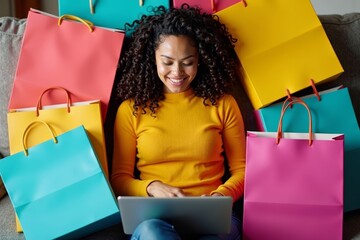 A woman surrounded by colorful shopping bags relaxes on a couch while browsing online