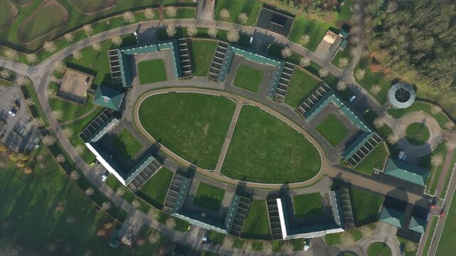 Aerial view of horse stables and green space, United Kingdom.