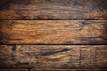 An intricately textured close up of weathered wooden planks showing a rich array of warm brown tones and deep grain patterns perfect for a rustic backdrop