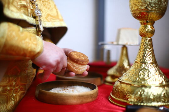 An Orthodox priest during the proskomidia removes holy particles from the prosphora. The concept of the Orthodox faith.