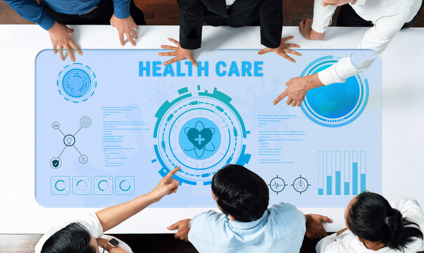 Teams collaborate over health care data displayed on a modern digital interface, showcasing innovative technology and insights in a professional office environment. Trope