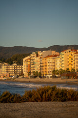 Obraz premium sunrise illuminating shoreline with tranquil ambiance, gentle waves and bright facades at sunrise by beach