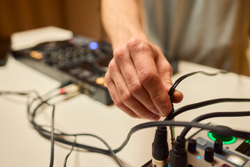 Engineer finetuning sound signals using patch cables, Focused technician adjusting levels on electronic patch cable setup with vivid colorful plugs and tactile interfaces