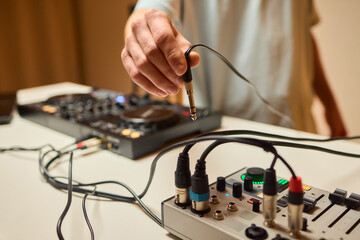 Engineer finetuning sound signals using patch cables, Focused technician adjusting levels on electronic patch cable setup with vivid colorful plugs and tactile interfaces