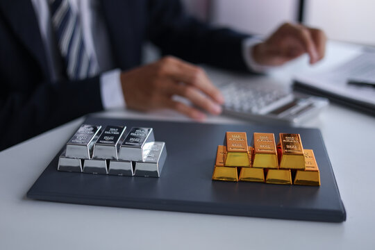 Businessman investing in precious metals gold and silver to diversify portfolios hedge against inflation and currency depreciation.