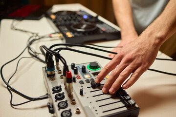 Closeup of tactile controls and vibrant patch cords in studio, Adjusting analog sequencing equipment with bright cables and warm ambient lighting in home studio