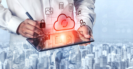 A business professional interacts with a tablet showcasing cloud technology and digital icons, symbolizing connectivity and data management in a vibrant city setting. Gantry