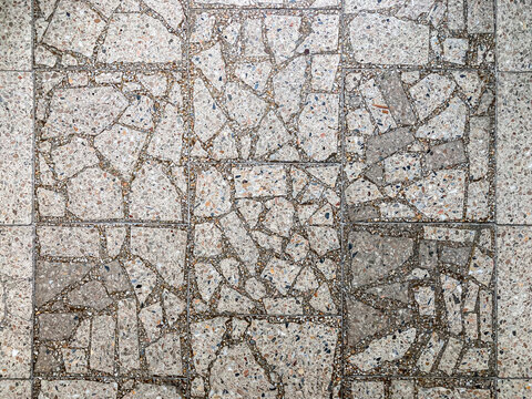 Close-up of textured wall with diagonal grid of rectangular tiles, showing color and material variations Earthy tones, soft lighting casting shadows Realistic style focusing on texture and pattern,