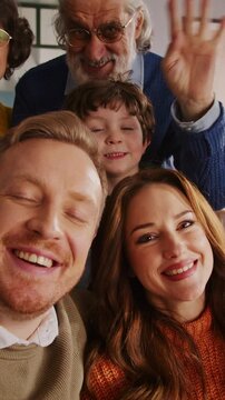 Big caucasian family waving hi to camera during video call