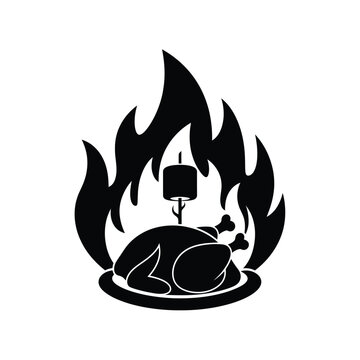 Whole chicken cooking on a spit over flames fire