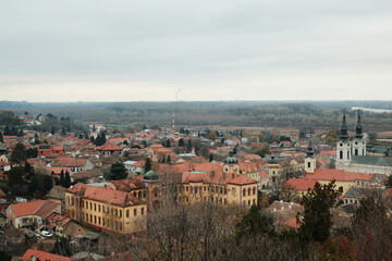 Obraz premium Historic rooftops of Sremski Karlovci with iconic yellow architecture and church towers. The scene conveys heritage, culture, and timeless atmosphere