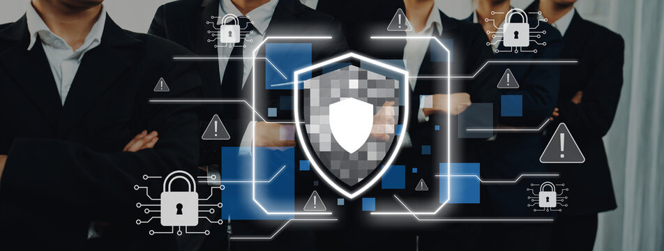Business professionals work together in a modern environment, focusing on cybersecurity. A digital shield icon represents the importance of data protection and security awareness. Trope
