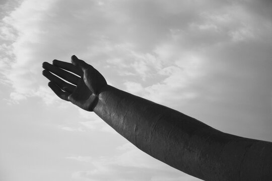 ręka na tle nieba caarno-białe, ręka figury lub rzeźby na tle czarnobiałego nieba, ręka posągu na tle czarno-białego nieba, the hand of statue against a black and white sky