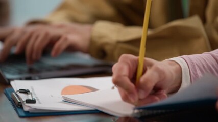 Close up informal business multiracial team working at table indoors Asian man Korean businessman typing laptop online chatting with clients research internet near woman writing notes analyze diagram - Powered by Adobe