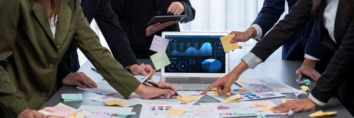 Analyst team use sticky note for creative and analytic brainstorm for business idea with BI data dashboard on laptop screen. Analysis financial data visualization tech for marketing strategy. Prodigy