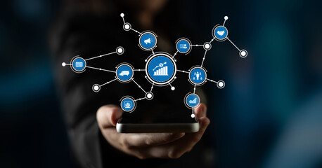 A person holds a smartphone displaying various icons that symbolize data analysis and growth in a digital business context, showcasing connectivity and innovation. Tessel