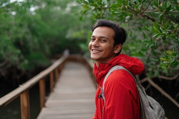 Young asian male smiling on nature walk in red jacket