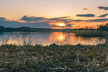 Sunset over a lake with a few trees in the background