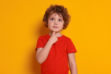 Portrait of cute little boy on orange background © New Africa