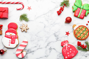Tasty gingerbread cookies and Christmas decor on white marble table, flat lay. Space for text