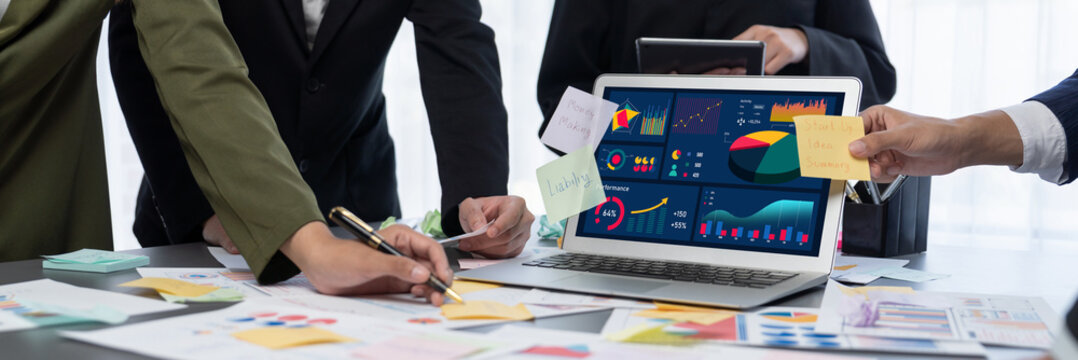 Analyst team use sticky note for creative and analytic brainstorm for business idea with BI data dashboard on laptop screen. Analysis financial data visualization tech for marketing strategy. Prodigy