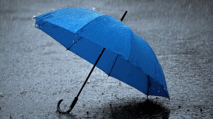 Obraz premium A blue umbrella is open in the rain. The umbrella is upside down and is in the water