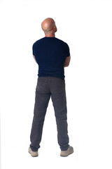 Fototapeta premium back view of a man standing amrs crossed and looking up on white background