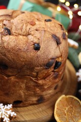 Tasty Christmas panettone cake with gingerbread cookie and dry orange slice on table, closeup