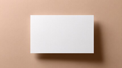 Blank white business card on beige background with soft shadows