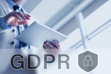 General Data Protection Regulation. Man using tablet computer indoors, closeup. Virtual GDPR abbreviation and shield with padlock. Privacy security