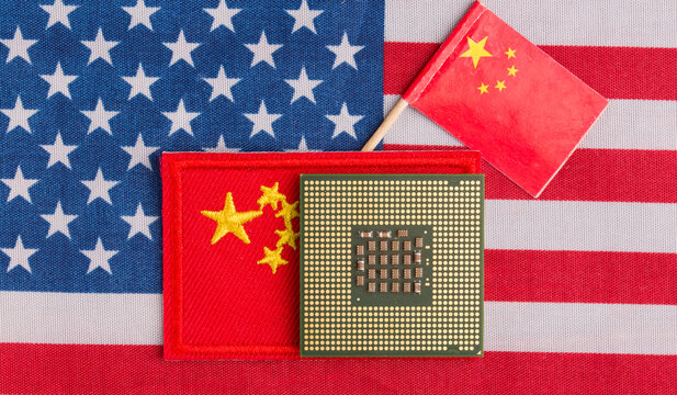A chip with a Chinese flag against the background of the US flag. Concepts of a trade war