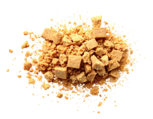 Overhead shot of crushed, crumbly, and cubed confectionery pieces scattered on black background