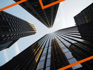 Low angle view of modern glass skyscrapers against clear sky with orange lines