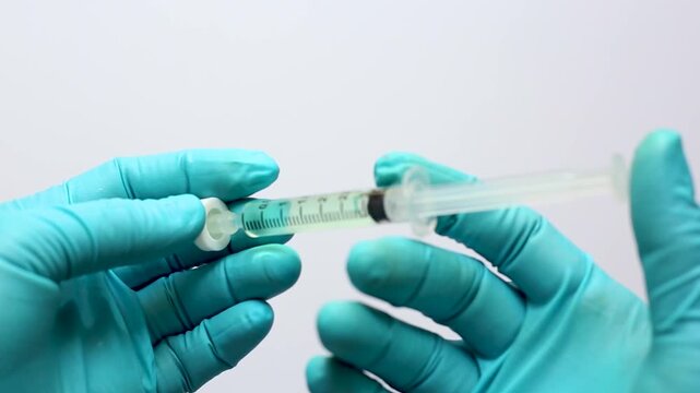 A scientist's hand grips a glass autosampler vial as a liquid sample is filtered through a microsyringe fitted with a filter membrane, removing particulates before HPLC or LC-MS analysis.