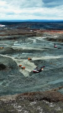open pit with heavy machinery, expansive quarry activity featuring multiple excavators and haul trucks