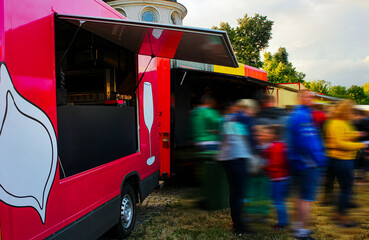 Street Food Truck Car at Festival with Pink Car & People are Waiting in Line to Order on a Warm...