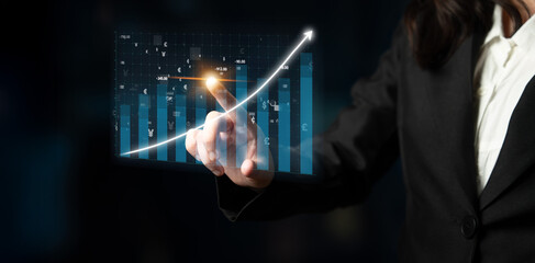 A businesswoman interacts with a virtual graph showcasing an upward trend, symbolizing growth and achievement in a dynamic business environment. Impute
