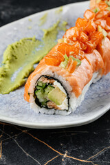 Close-up of fresh sushi featuring salmon, with perfectly rolled rice and garnishes, highlighting the vibrant orange color, textures, and appetizing presentation of the Japanese dish.