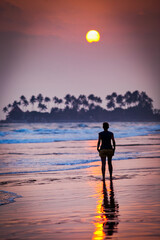 silhouette of woman walking on sunset beach