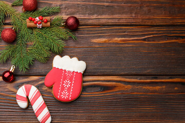 Tasty gingerbread cookies, cinnamon and Christmas decor on wooden table, flat lay. Space for text