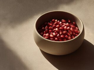 Pomegranate seeds in a minimalist bowl, soft light, neutral tones