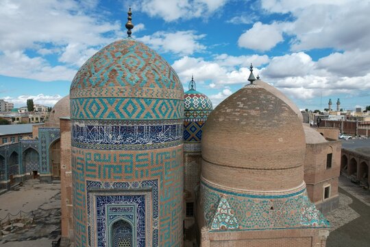 Aerial view of the intricate turquoise and brown tilework of Sheikh Safi al-Din Khanegah and Shrine Ensemble's domes, Ardabil, Iran.