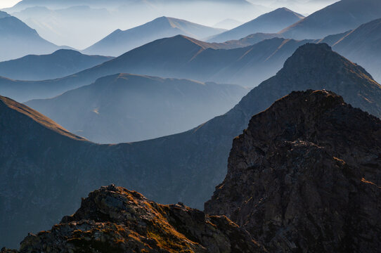 Aerial view of layered mountain ranges fading into the misty horizon, the rugged peaks of Tri Kopy standing boldly against the soft, ethereal backdrop., Ziar, Zilina Region, Slovakia.
